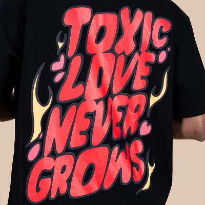 The 'Toxic Love Never Grows' graphic tee features a bold, statement back print using a mix of screen and puff printing on heavy 280 GSM terry cotton.