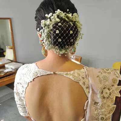 A classic bridal bun adorned with a net of baby's breath flowers. This is a delicate and romantic choice, perfect for a bride who loves a soft, ethereal look.