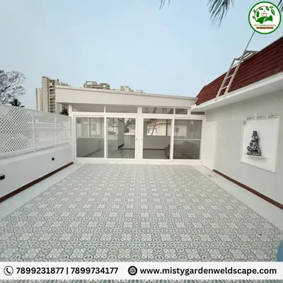 This is the exterior of a completed terrace room at Skylark Greens. It features a durable PUF sheet roof, UPVC sliding doors, and a PVC lattice privacy screen, all in a clean white finish that brightens the space.