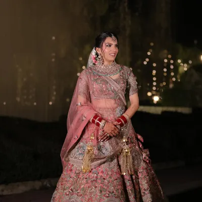 A full view of Muskaan's stunning pastel pink lehenga. The makeup was designed to be soft and romantic, with pink hues on the eyes and lips to create a cohesive, modern bridal look.