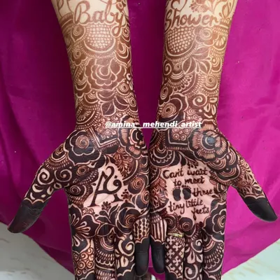 A complete baby shower mehendi design with "Baby Shower" written across the arms. One palm has the initial 'A', while the other has the sweet quote, "Can't wait to meet these tiny little feet."
