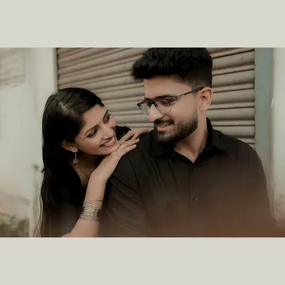 An intimate close-up in an urban setting. The soft, moody lighting creates a cinematic feel, focusing entirely on the couple's connection.