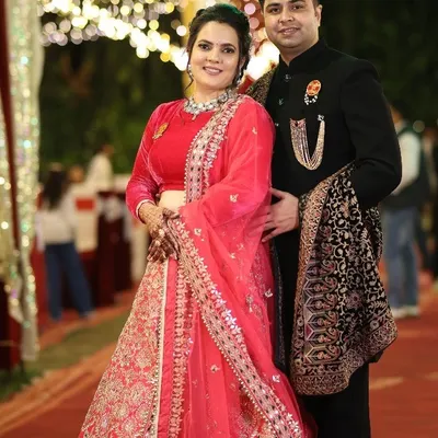 Our clients look radiant at their reception. The groom is wearing a regal black bandhgala with a statement brooch and a beautifully detailed shawl, a perfect choice for an evening of celebration.