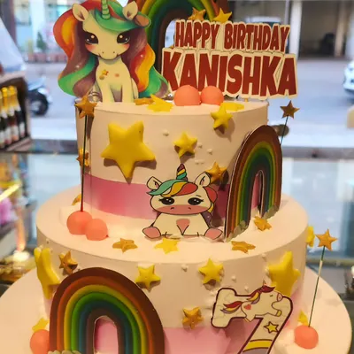 A magical two-tier unicorn birthday cake decorated with rainbows, stars, and adorable unicorn figures. This is one of my most popular designs for kids' parties.