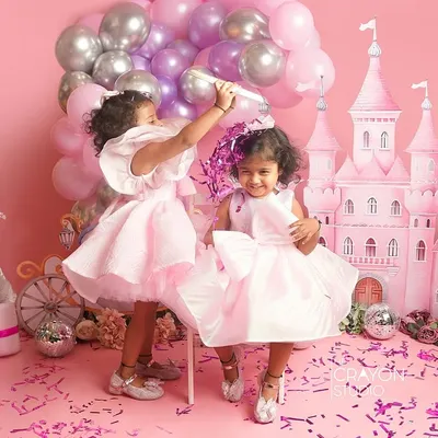 A shower of confetti in a pink princess castle. This action shot captures the pure, uninhibited joy of two sisters celebrating in a world we created just for them in the studio.
