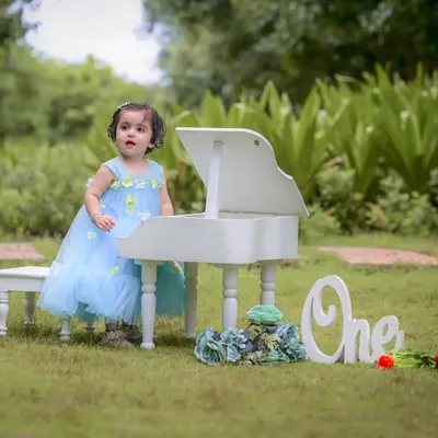 Celebrating a first birthday is a huge milestone. For this outdoor session, we used a mini white piano and a "One" sign to create a sweet, memorable scene for Naira's special day. Milestone photography is about celebrating these precious firsts.