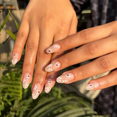 A fresh and delicate look perfect for spring. We hand-painted these tiny white daisies on a sheer nude base, adding a single pink rhinestone in the center of a few flowers for a subtle sparkle.