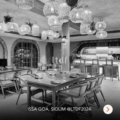 ISSA Goa, a riverside retreat we designed, blends Mediterranean and Modern European style with Goan charm. This black and white shot highlights the textures and forms, from the woven pendant lights to the arched windows, creating a timeless and elegant dining space.