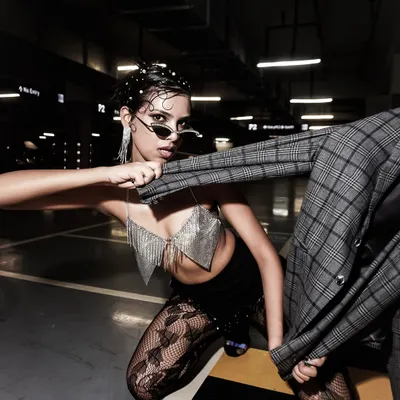A raw, high-fashion moment in an underground parking lot. The industrial setting and dramatic lighting create a very edgy and powerful image.