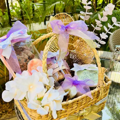 This hamper is a beautiful example of color customization, designed in soft shades of lilac, lavender, and white. It contains gourmet cookies, almond biscotti, and hummus, all elegantly wrapped.