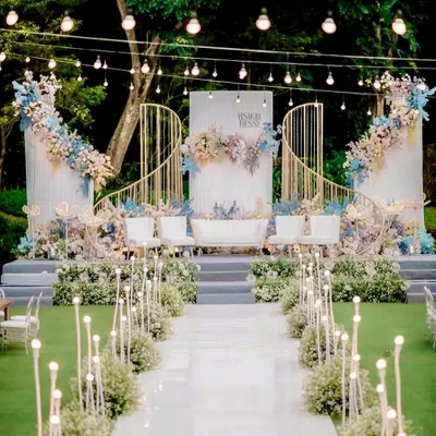We created a dreamlike atmosphere for this outdoor wedding with a magnificent all-white stage. The elegant arches, pastel floral arrangements, and softly lit aisle created a truly romantic and sophisticated setting for the couple to say "I do".
