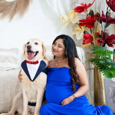 The perfect family portrait, including the fur baby. This adorable shot features an expecting mom with her well-dressed dog, celebrating the expansion of their family.
