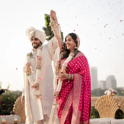 A moment of pure triumph and happiness as the couple celebrates their union under a shower of petals during their golden hour wedding ceremony.