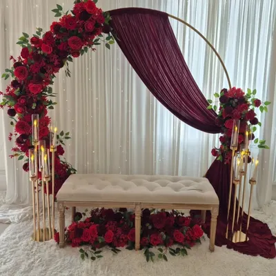 A romantic and elegant stage setup perfect for a ring ceremony or reception. This design features a circular arch with rich red roses, draped fabric, and tall candle stands for a warm, intimate glow.