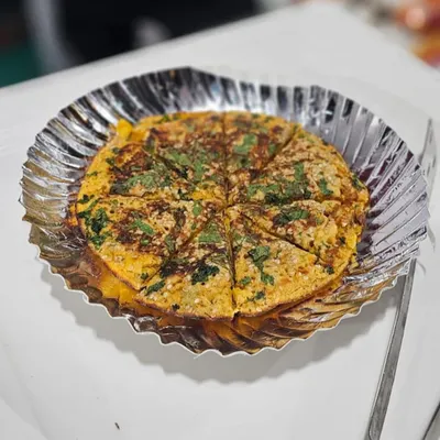 A freshly made pudla, a savory Gujarati pancake, garnished with fresh coriander. This is a popular live counter option that I can arrange for sangeet or mehndi functions.