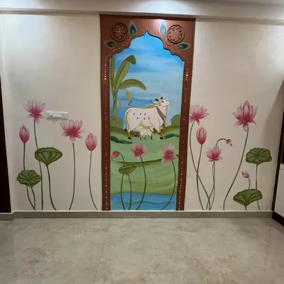 A full view of our Pichwai-inspired wall art. The central panel features a cow and calf, created in relief, while the surrounding wall is painted with beautiful lotus flowers. The arch is decorated with lippan art using ropes and mirrors.