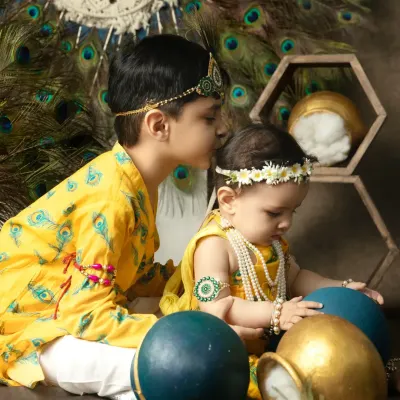A touching moment between two brothers dressed for Janmashtami, as the older one places a protective kiss on his baby brother's head.