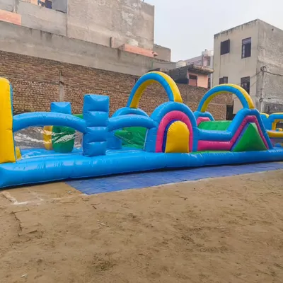A full view of a long, multi-element inflatable obstacle course. This design includes arches to crawl under, barriers to climb over, and pop-up obstacles, providing a continuous challenge from start to finish.