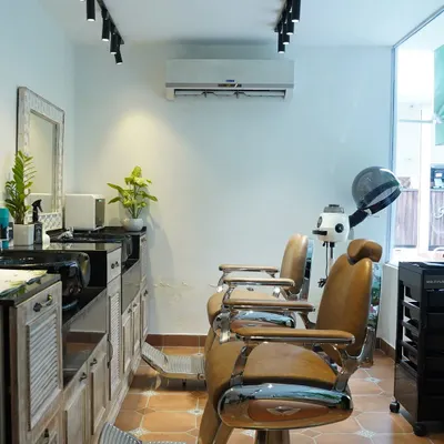 I believe privacy is essential for true relaxation. This is a view of my dedicated men's grooming area at the Chanakyapuri branch, featuring classic barber chairs and a quiet, comfortable atmosphere for you to disconnect.