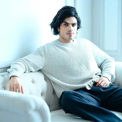 A clean, high-key portrait of a male model on a white sofa. This shot is perfect for a commercial or editorial portfolio, showcasing a relaxed yet sophisticated look.