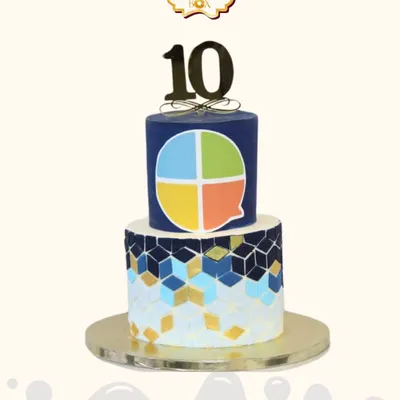 A sharp and modern cake celebrating a decade of success for Scroll Mantra. This two-tiered design features the company's logo and a geometric pattern in their brand colors.