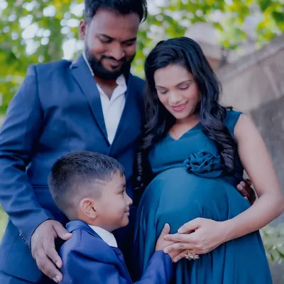 I love capturing the entire family. Here, the older brother looks lovingly at his mom's baby bump. We can provide matching outfits to create a coordinated family look.