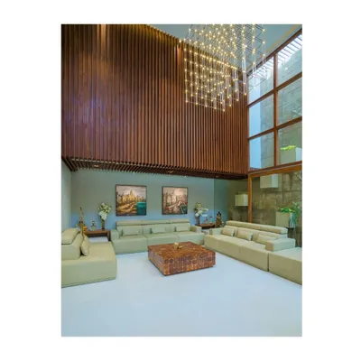 The double-height living area in our Athulyam project is designed to feel grand and airy. We used vertical wood paneling to accentuate the height and a massive, custom chandelier to fill the volume, creating a space that is both impressive and comfortable.