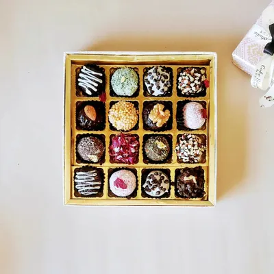 A top down view of our Crunchy Chocolate Truffles box. Each truffle has a different topping, including chocolate chips, chopped nuts, sprinkles, and desiccated coconut for a variety of textures.