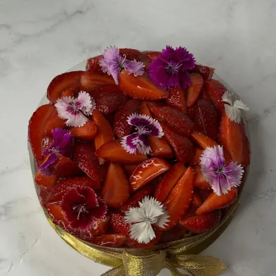 My Basque cheesecake, reimagined with fresh strawberries. It's laid over a bed of my house-made strawberry compote and topped with beautiful edible flowers. It's available in both sugar-free and regular versions.