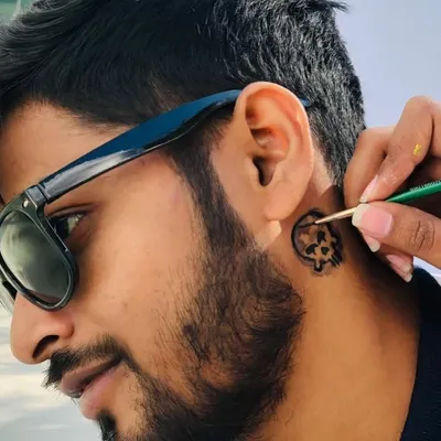 Getting this client ready with a cool skull temporary tattoo behind the ear. It's a small detail that adds a lot of edge to a look.