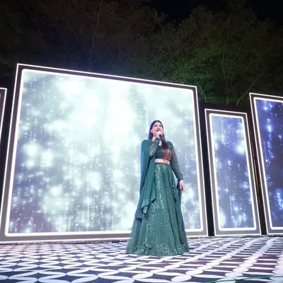 On stage at a beautiful outdoor Sangeet. The stunning LED backdrop set the mood, and I made sure my energy matched the vibrant setting to keep the celebration going all night.