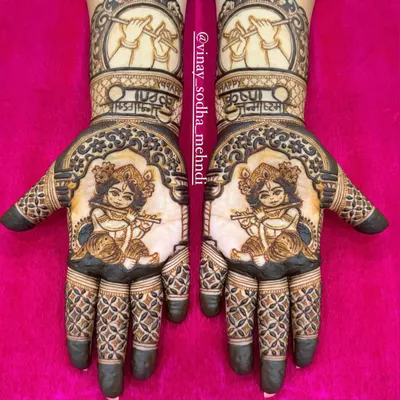 A stunning symmetrical design for Janmashtami. Both palms feature a portrait of little Krishna playing his flute, with his hands holding the flute depicted on the forearms.