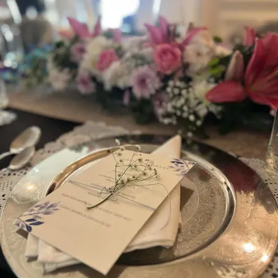 The table is set for our first-ever sit-down lunch. Each place setting includes a printed menu and a sprig of baby's breath, small details that elevate the dining experience.