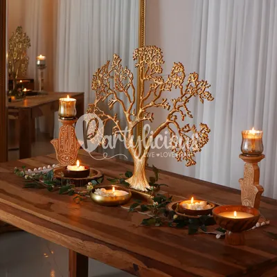 A golden Tree of Life centerpiece creates a stunning focal point on this rustic wooden table, surrounded by the warm glow of candles. This is festive decor that feels both traditional and timeless.