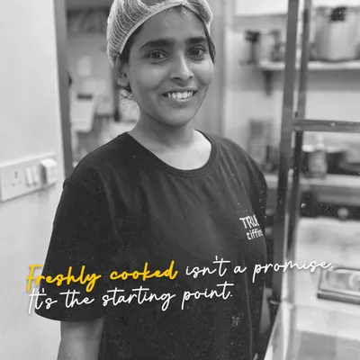 This is one of our dedicated team members. The message here is our core philosophy: "Freshly cooked isn't a promise, it's the starting point." For us, balanced meals, variety, and on-time delivery are the standard, not a special feature.
