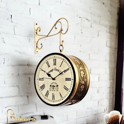 Our brass carving dual station clock features intricate floral patterns on the casing, mounted on a white brick wall to highlight its vintage charm.