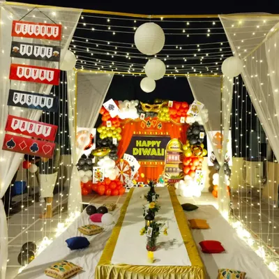 A complete casino-themed Diwali party setup on a terrace. We created a canopy with fairy lights and drapes, with a themed backdrop, low seating arrangement, and custom props.