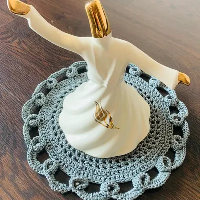 This grey doily features a beautiful, intricate openwork border. It's a classy and elegant piece that adds a touch of sophistication to any surface.