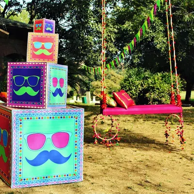 This outdoor Mehendi setup captures my signature style: bold, fun, and full of personality. I designed the custom graphic boxes and the decorated pink swing to create a vibrant, Instagram-worthy corner for the celebration, perfect for a daytime event.