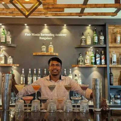 One of our skilled bartenders proudly displaying a full bar of colorful cocktails he's prepared.