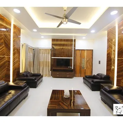 This living room achieves a warm, luxurious feel through the extensive use of polished wood veneer on the walls. The vertical panels are backlit to create a soft glow, highlighting the intricate patterns of the wood and complementing the dark leather sofas.