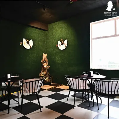 A quiet corner with our signature checkered floor and unique wall art. I've designed every part of the pub to have its own character and vibe.