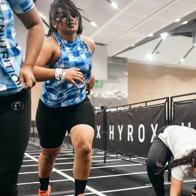 An action shot from the Hyrox Delhi competition. This event is the ultimate test of functional fitness, combining running with various strength stations.