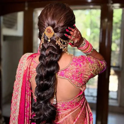 A stunning traditional braid for a Maharashtrian bride. The hairstyle is intricate and elegant, adorned with a beautiful gold accessory.