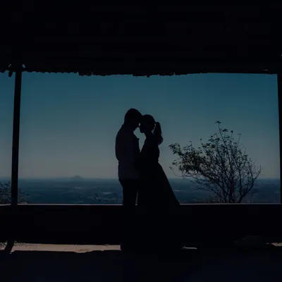 A beautiful silhouette of a couple against the vast sky. This artistic shot captures a feeling of intimacy and endless possibilities.
