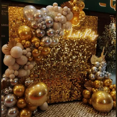 A glamorous photo backdrop combining a gold sequin wall with a metallic gold and silver balloon arch. The "Let's Party" neon sign makes it an instant focal point for any high-energy celebration or corporate gala.