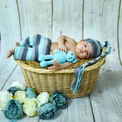 This one-month-old is wide awake and curious. We use cozy props like this wicker basket and handmade outfits for our newborn and infant photoshoots.