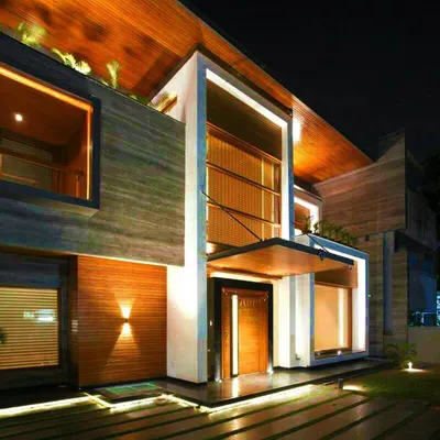 A closer look at the 'Kohinoor' residence, where warm-toned lighting accentuates the rich textures of the facade. This architectural lighting design ensures the home feels as grand and detailed at night as it does during the day.