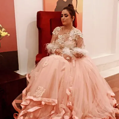For a truly grand occasion like a wedding reception or cocktail event, a gown like this peach tulle creation with feather details makes a breathtaking statement. I help clients find silhouettes that feel both regal and personal.