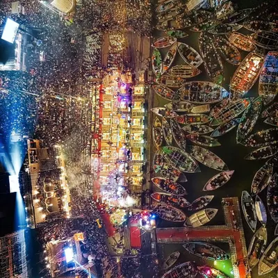 A breathtaking top-down view of the Ganga Aarti in Banaras. This image captures the scale of devotion, with thousands of lamps lighting up the ghats and countless boats filling the sacred river.